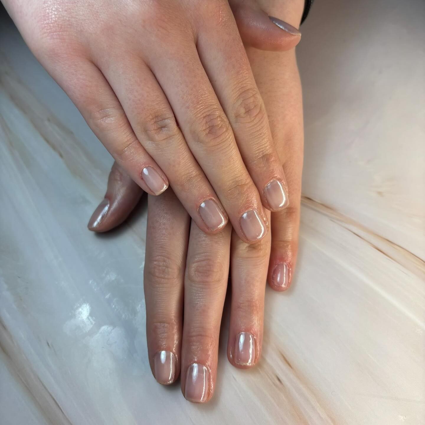 Short nude builder gel nails with a soft chrome sheen